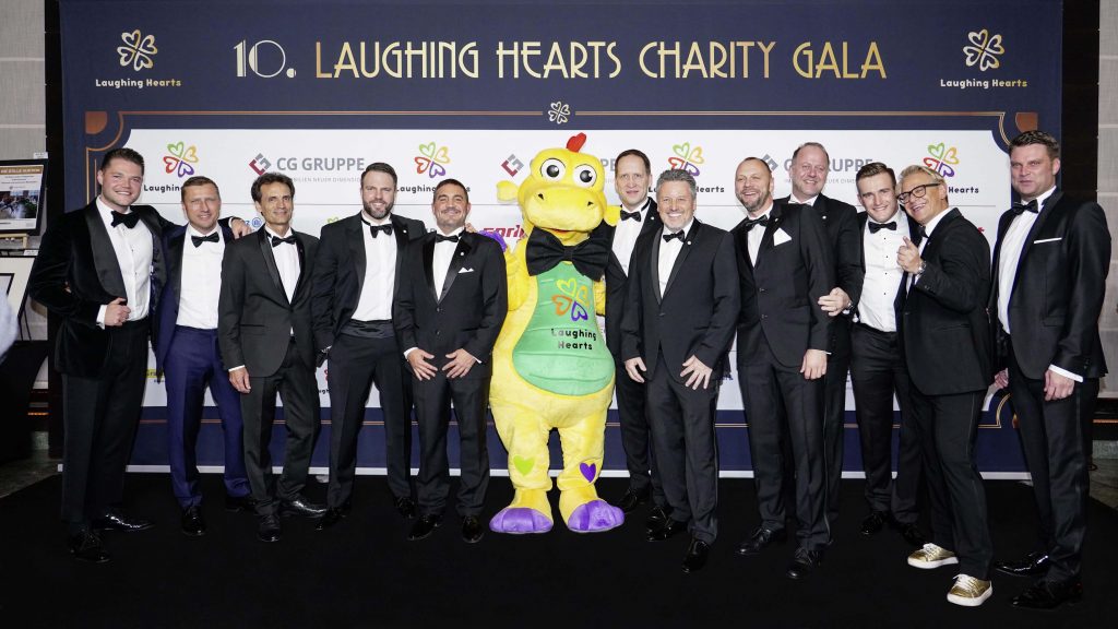 Laughing Hearts 2018 10. Laughing Hearts Charity Gala Vorstand mit Maskottchen Hartmut Pressewand
